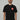 Black Red Shield Elite Mens Tee shown on a male model standing front-facing, featuring the red Gracie Barra Red Shield emblem on the left chest and red sleeve tag against a light gray background.