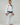Adult athlete wearing the white GB1 Kimono in an angled front stance, showing the Red Shield chest patch, Gracie Barra lapel patch, reinforced jacket structure, and tapered performance fit.