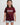 Young girl wearing maroon t-shirt with puff print "Gracie Barra Brazilian Jiu-Jitsu" logo, smiling against a white background.